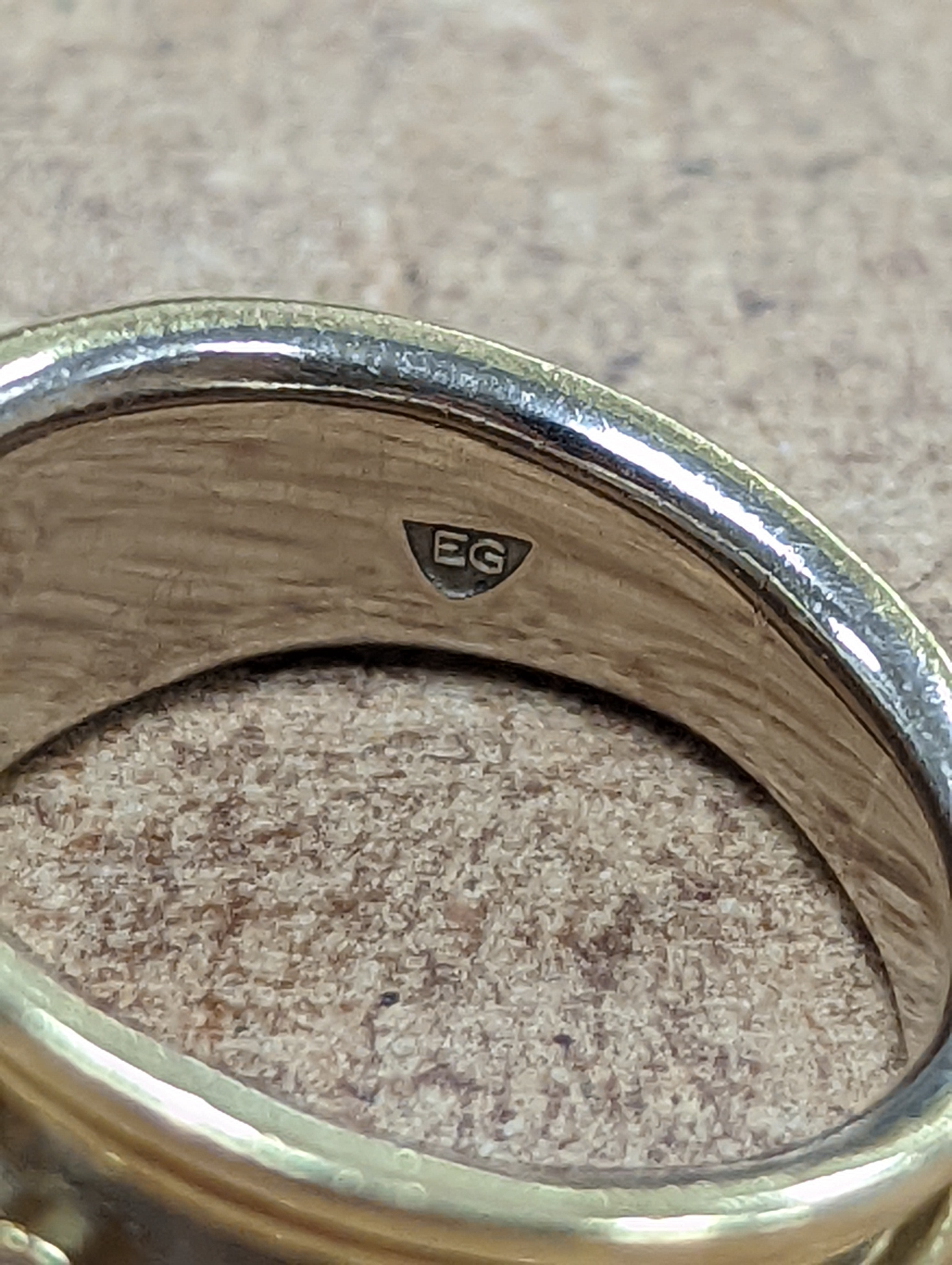 A modern two colour 18ct gold and three stone diamond set dress ring by Elisabeth Gage, size K/L, gross weight 7 grams, with engraved date to shank interior.